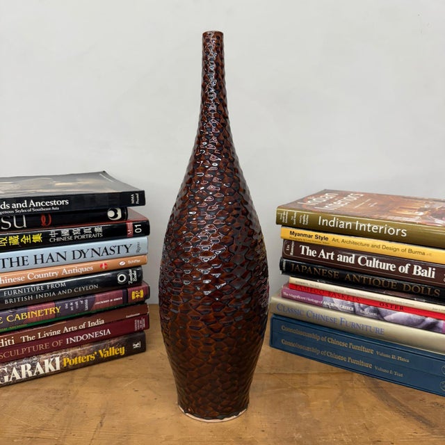 "About This Piece About This Piece This vase radiates depth and warmth with its scaled surface that ripples like glowing...