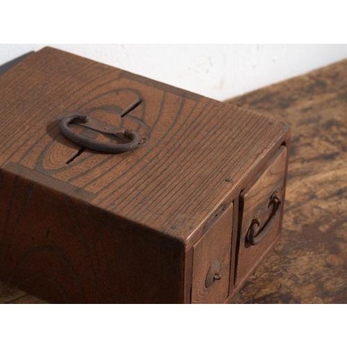 This antique Japanese wooden box is a portable storage piece made of solid wood, produced in Japan between the late 19th...