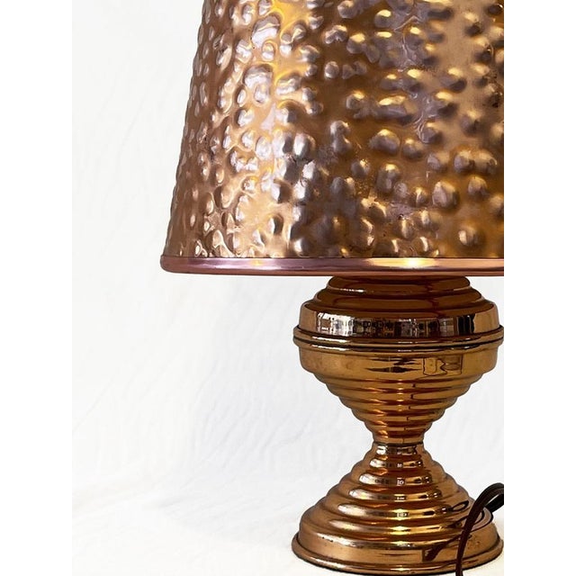 1930's Art Deco hammered copper fixed lampshade and base. The lampshade being made of hammered copper funnels the light...