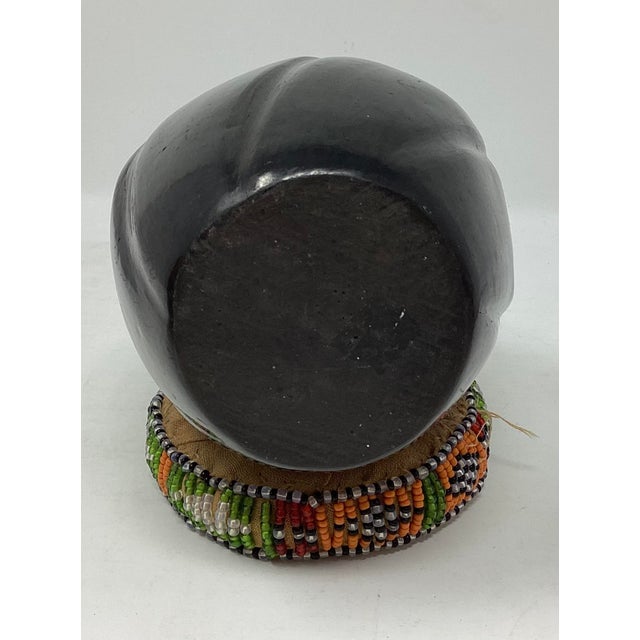 Santa Clara Pueblo pottery is renowned for its hand-coiled, highly polished blackware and redware, often featuring deep,...
