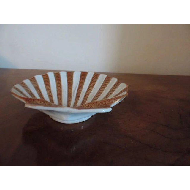 A fine and rare 18th c. Chinese export porcelain sea shell decorated in bands of iron red / orange enhanced by gilding....