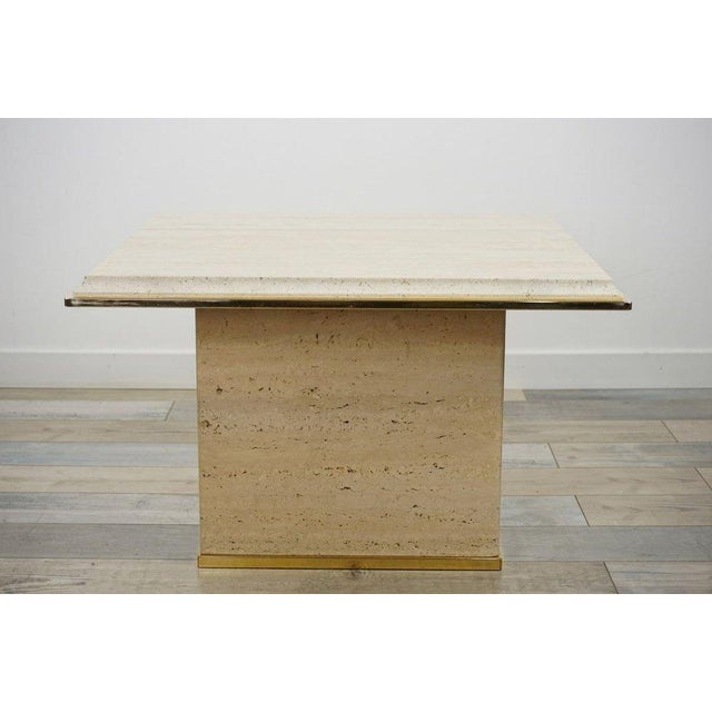 You will be captivated by the charm, elegance, and presence of this travertine and brass coffee table in the Hollywood...