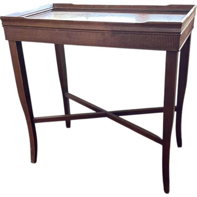 A refined antique mahogany occasional table from the early 20th century. It is heavily inspired by 18th-century English...