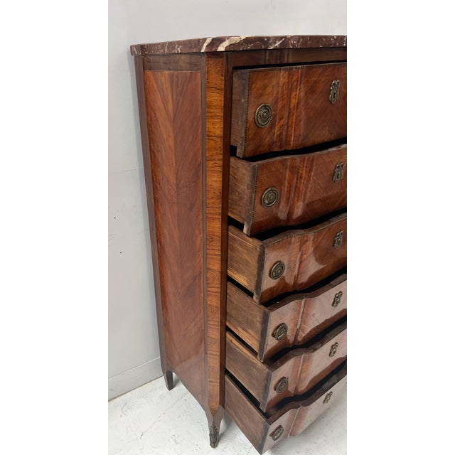 Transitional-style chest of drawers in wood veneer Front features a central recess and side panels with flat edges Six...