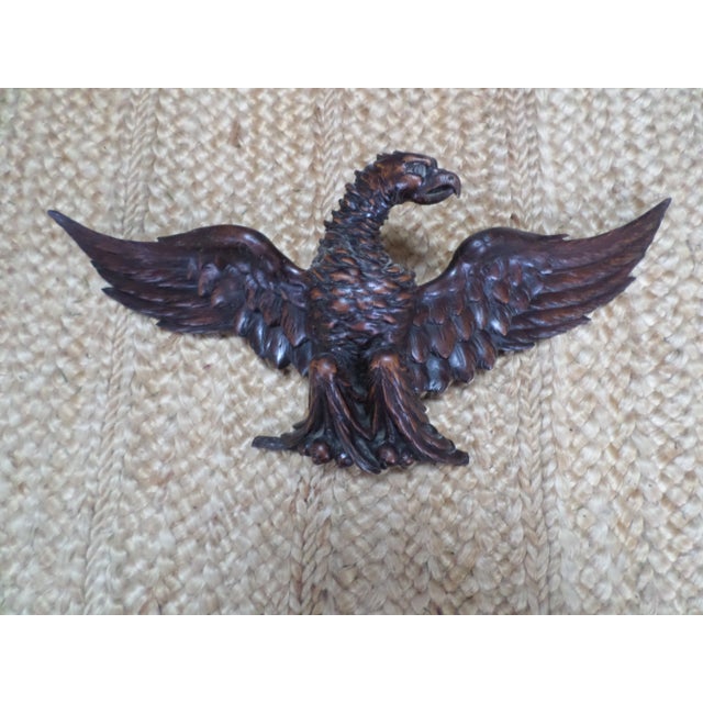 An impressive and intricately-carved wooden eagle of impressive proportions, with wings spread as if it is about to take...