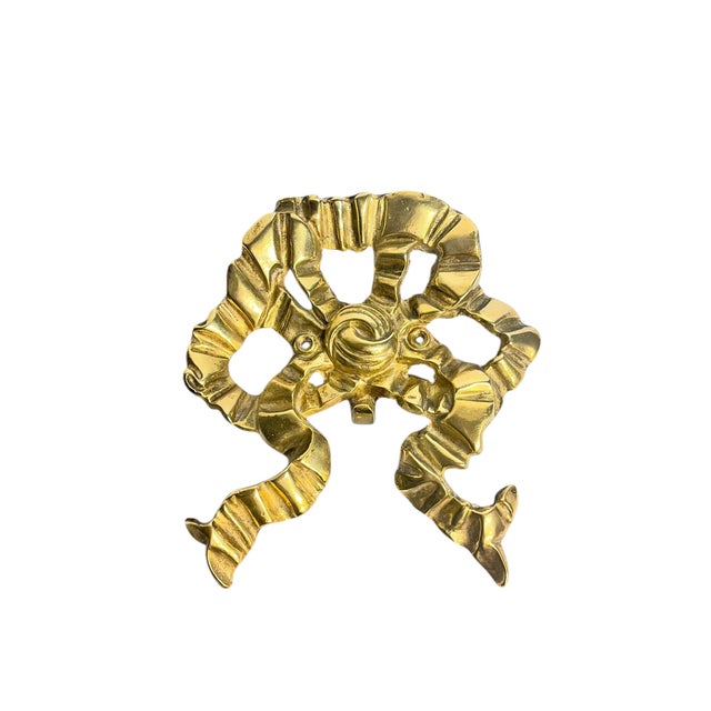 Larger size brass bow with a small central hook. Has a slight French provincial style to it. Perfect for a bathroom! Has...