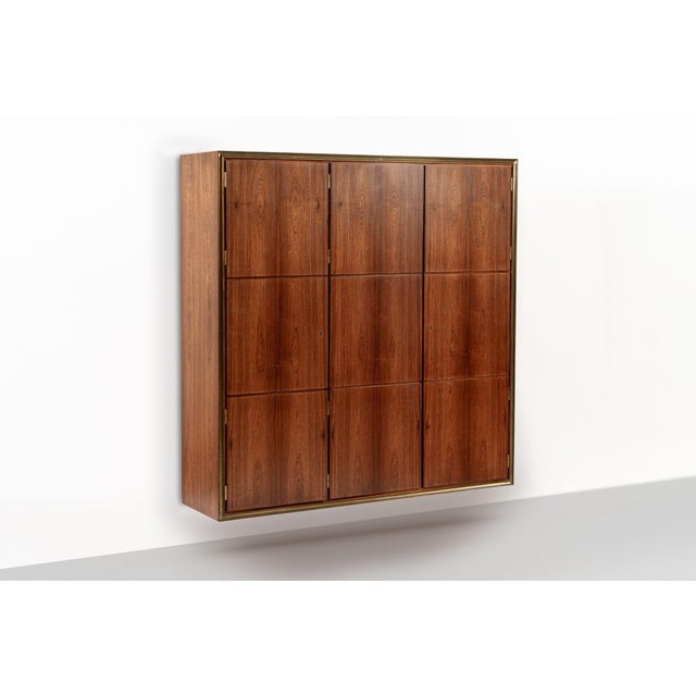 This truly stunning vintage mid century Danish modern rosewood wall-mounted cabinet shelving unit circa 1950 was designed...