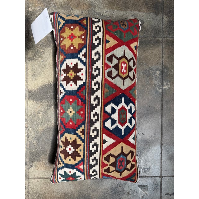 A vibrant celebration of antique textile tradition, this 19th century Caucasian kilim lumbar pillow showcases masterful...