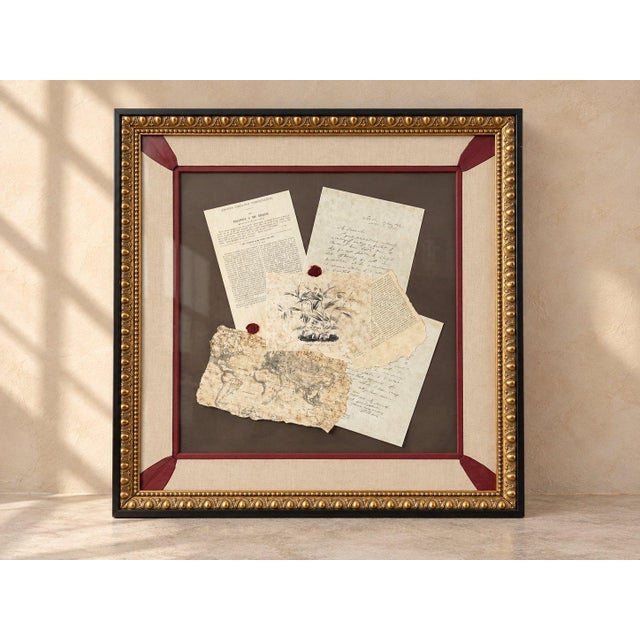 Real handwritten letters, a printed page, a torn map, and a botanical print sit under glass with two red wax seals on a...
