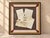 Real handwritten letters, a printed page, a torn map, and a botanical print sit under glass with two red wax seals on a...