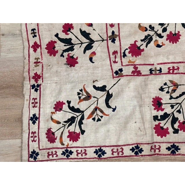 A stunning Uzbek Suzani, Nurata Region, c. 1850. Worked in colored silks with a central medallion surrounded by floral...