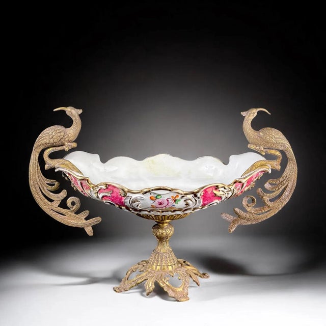 A striking large-scale decorative centerpiece featuring an elegant porcelain bowl held within an ornate gilt metal mount...