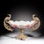 A striking large-scale decorative centerpiece featuring an elegant porcelain bowl held within an ornate gilt metal mount...