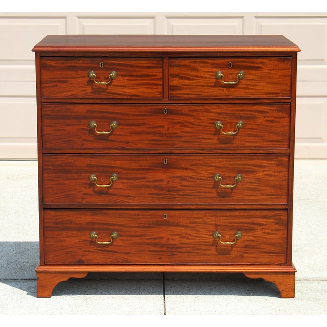 A refined example of classic English craftsmanship, this late 18th-century Georgian-style chest of drawers embodies...