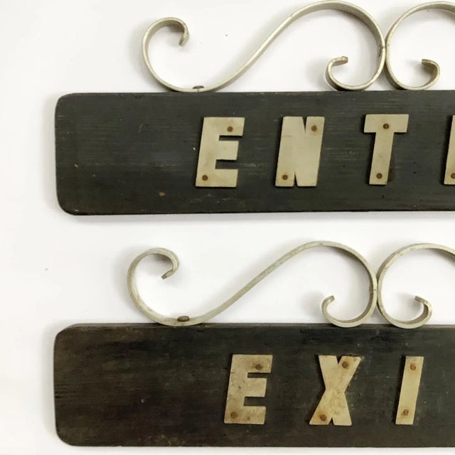 Pair of mid-century homemade wood and metal exit and enter signs, applied metal letters on dark brown wood boards with...
