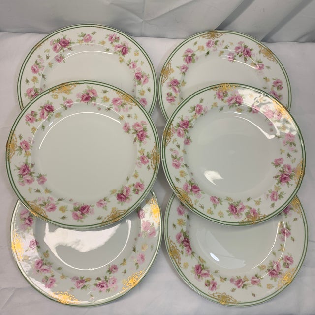 Offered here are vintage porcelain plates featuring a pink rose floral border with ornate gold and green trim, classic...