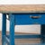 Rustic pine work table with base in old blue paint and two large metal drawers. The natural wood top bears deep gouges,...
