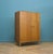 Compact mid-century wardrobe in oak by Meredew. Clean, simple design with round wooden handles and tapered legs. Left side...