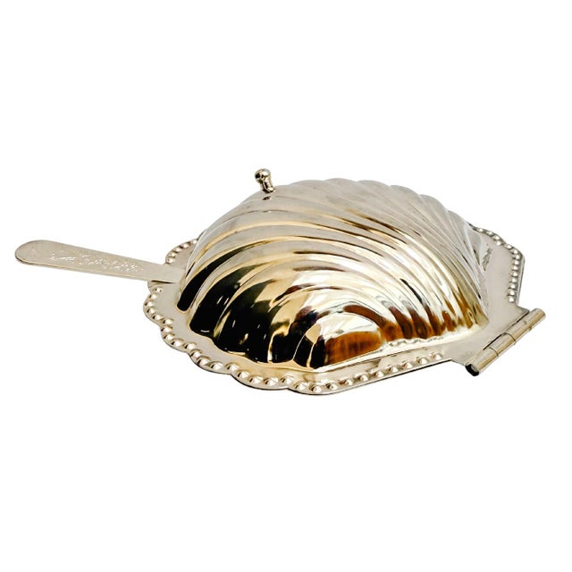 Whimsical silver-plated caviar dish in the form of a stylized shell. The hinged shell lifts to reveal a fitted glass liner...