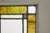 Antique Arts & Crafts style stained glass window featuring a classic symmetrical geometric design. The frame is made of...