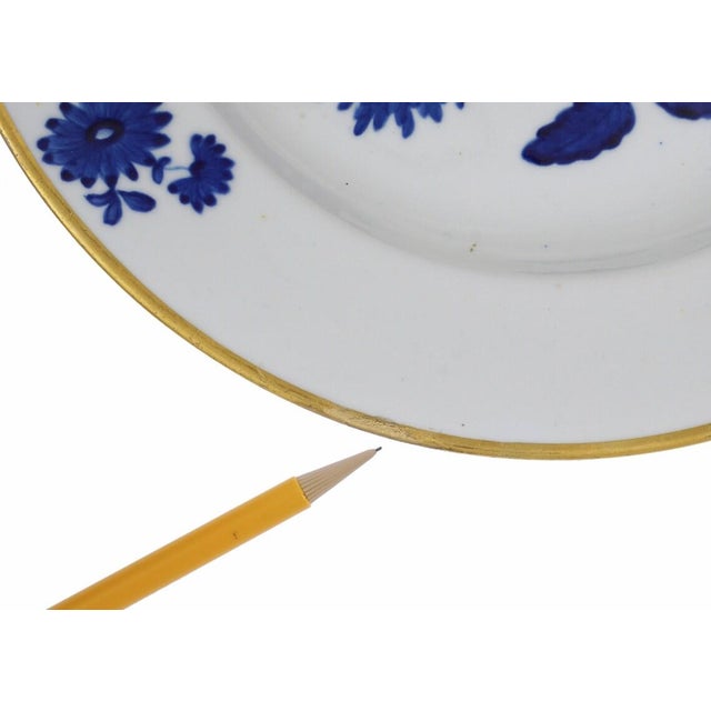 Decorated with large, bold, hand-painted blue flower bouquets and gilt rim on a bright white ground. They are marked on...