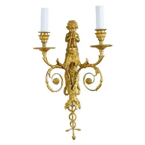 Pair of French gilt bronze sconces with two candles each, in the Louis XVI style. They are decorated with twisted, floral...