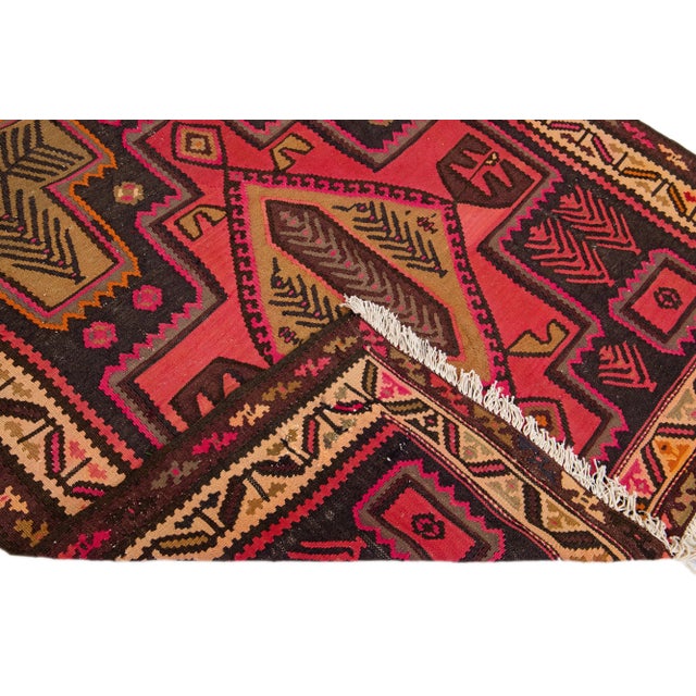 Beautiful vintage Turkish Kilim hand-knotted wool rug with a pink field. This piece has a beige frame and multicolor...