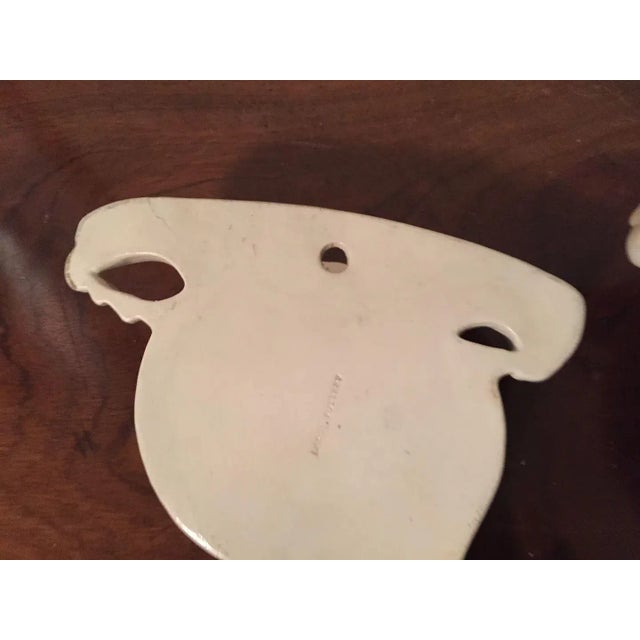 Pair antique 18th c. English creamware cornucopia form wall pockets. Each with a central mask and handles in the form of...