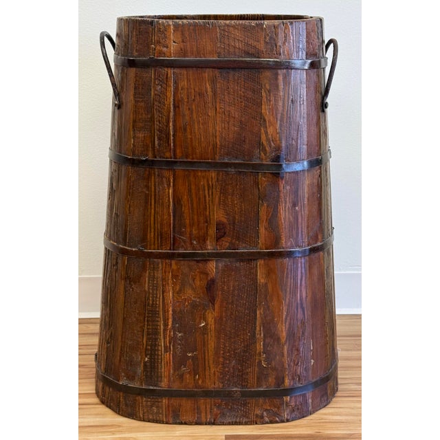 Oversized antique wooden bucket used in India to store grain. This is solid and heavy with a beautiful patina. Metal...
