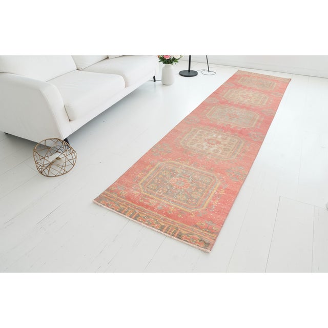 This is a vintage Turkish Oushak rug from the Mid 20th Century. The piece was hand-knotted.