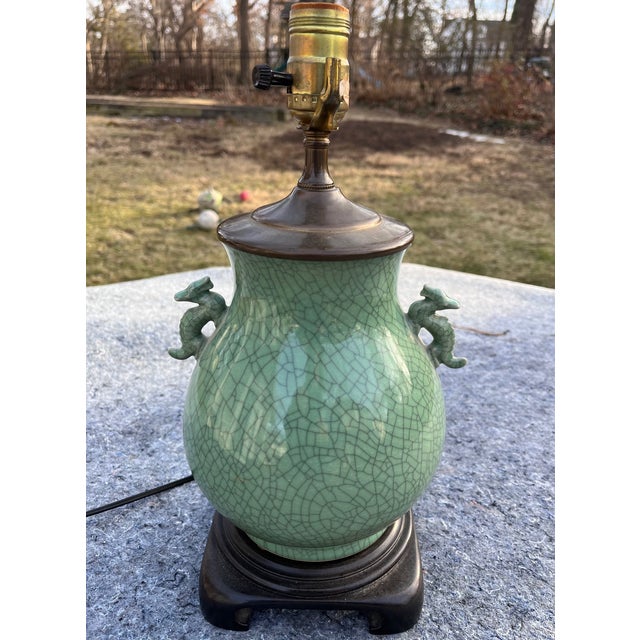 Celadon crackle vase table lamp on wooden stand featuring dragons on each side. Just perfect for so many interiors!