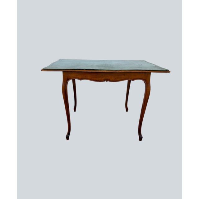 A leather top Game Table with a Louis XV-style set of four Side Chairs. Carved top rails, cabriole legs. Chairs are...