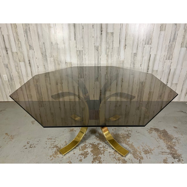 Brass, burl, & smoked octagonal shaped glass dining table in the style of Mastercraft, Lotus design with four curved brass...