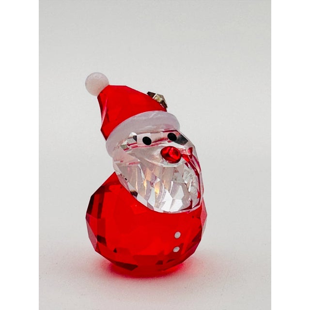 Like-new-with-original-box, this petite and charming Swarovski "Rocking Santa" figurine (No. 1143323) is in excellent...