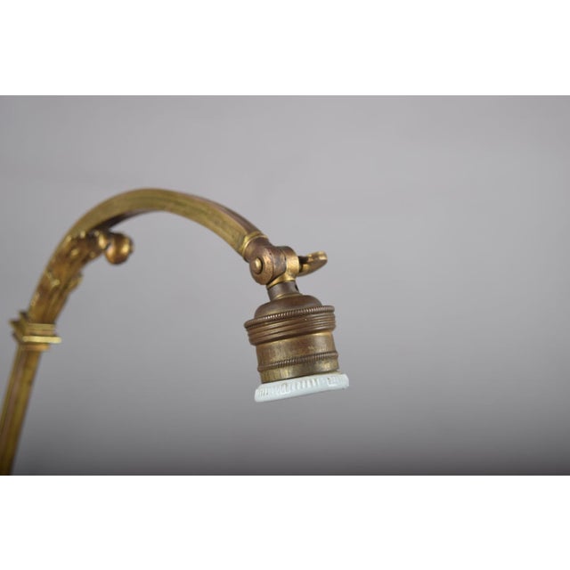 A charming and finely detailed art nouveau style brass desk lamp, combining the graceful arched gooseneck form with an...