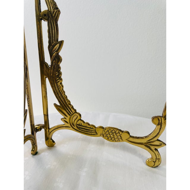 This large brass easel is foldable and cast with scrolls, foliage and stylized pineapples. Perfect for plates, large...