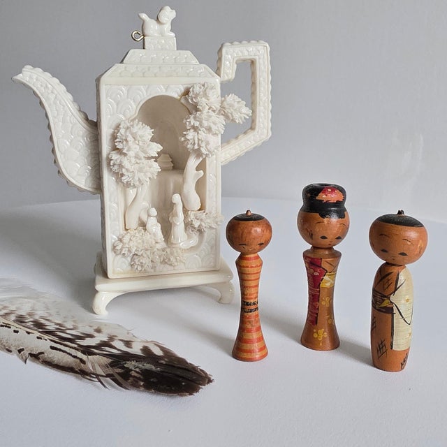 This charming trio of miniature Kokeshi dolls originates from mid-century Japan, showcasing traditional artisan...