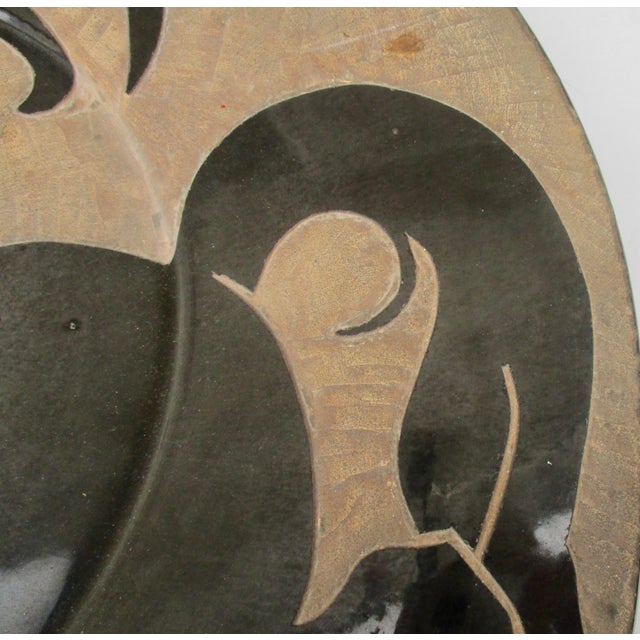 Stoneware charger from Biot, France, vintage 70s. Glazed in glossy black over the whole, the horse image is drawn on the...