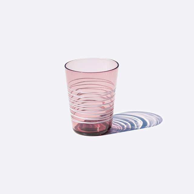 Handmade colored tumblers in mass-colored glass, blown in light shades with a spiral of "lattimo" glass threads applied...