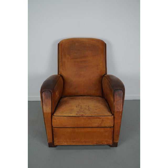 This leather club chair comes from France and was made circa 1950s. It is upholstered with cognac-colored leather and...
