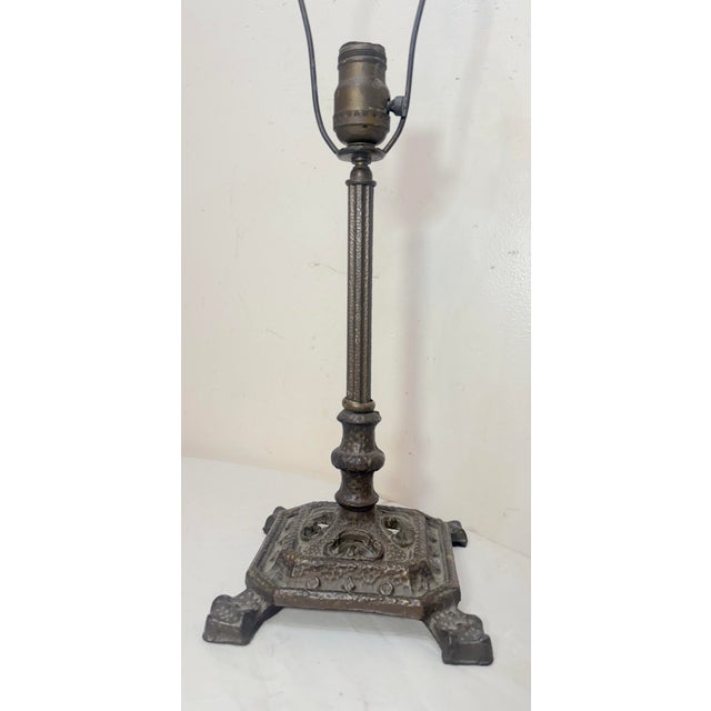 This antique Arts and Crafts bronze patinated cast iron electric table lamp is a unique and stylish addition to any home...