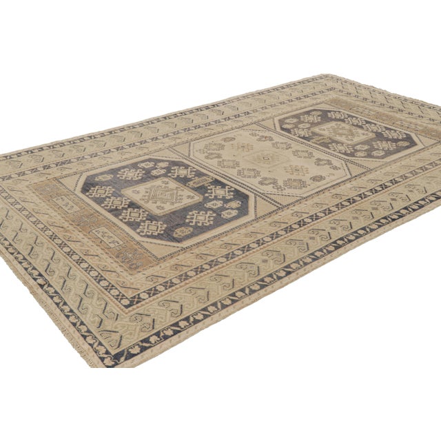 Hand-knotted in wool, this 6x10 vintage Turkish rug, circa 1950-1960, features interesting soft colors for a work of its...