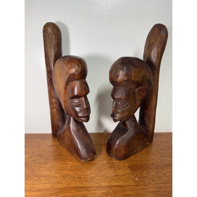 Beautiful vintage pair of hand-carved wooden figural bookends featuring two stylized busts facing one another. Rich warm...