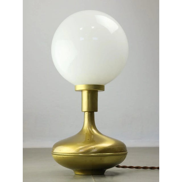 Beautifully formed table lamp in brass and opaline glass. The lamp socket is designed for standard European E14 light-bulb...