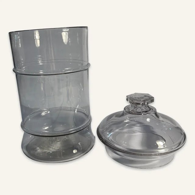 Mid 19th century Pittsburgh glass jar with lid. The lid is domed and the finial is flat and hexagonal. The body of the jar...