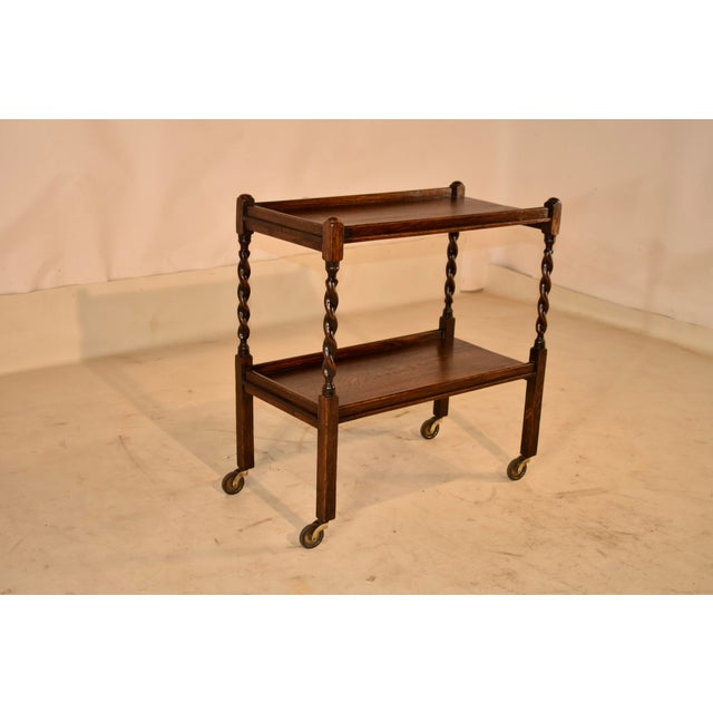Period Edwardian oak bar cart from England, circa 1900. This cart has two shelves, both with galleries surrounding them on...