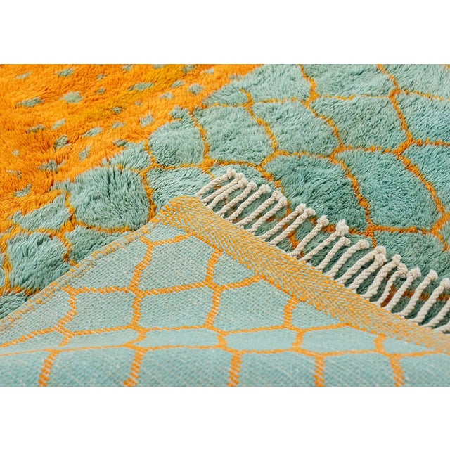 Patterned hand-knotted wool rug in refreshing Blue Turquoise and Orange, featuring a lattice pattern with dotted accents....