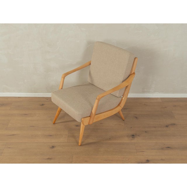 A wonderful armchair from the 1950s. High-quality beech frame. The armchair has been reupholstered and covered with a...