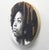 This artwork features a striking portrait of a young woman, rendered in charcoal and pastel, with a focus on her...