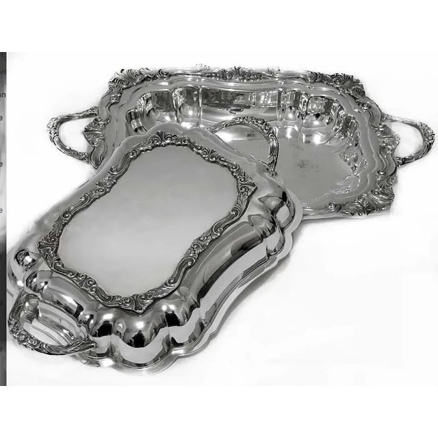 Vintage silver plate covered serving dish with ornate, rococo-style handles and decorative details on the rim. An elegant...